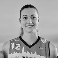 A woman wearing a sporty jersey with the number 12 and a city skyline design.