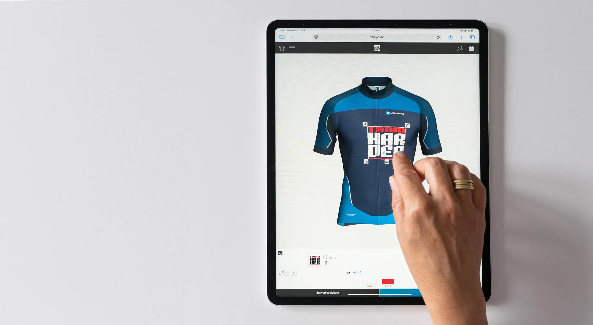 A hand interacts with a tablet displaying a customized cycling jersey design interface from owayo, editing a blue jersey with a red and white design.