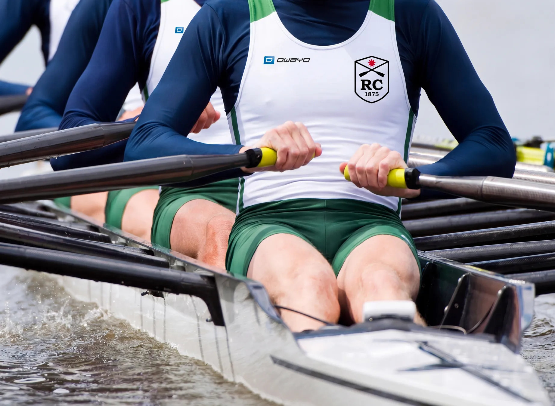 Three rowers in customized sportswear are rowing synchronously in a boat.